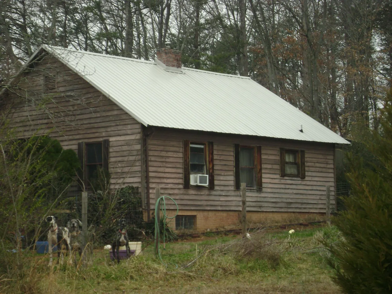 White metal roof on an old wood sided farmhouse, from a Metal Roof Installation job in Pikeville